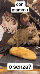 a man is cutting a loaf of bread in front of a sign that says " con mamma o senza "
