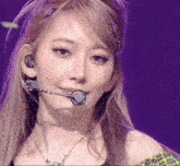 a close up of a woman 's face wearing a microphone