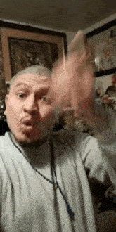 a man with a beard and mustache is making a funny face and waving his hands in the air .