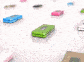 a green toy with a face is sitting on a table next to other toys