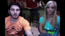 a man and a woman are sitting next to each other and the woman is wearing a t-shirt that says " armor "