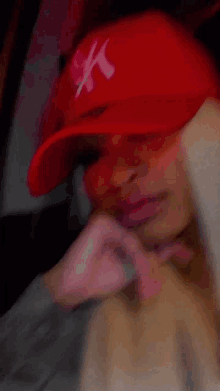 a woman wearing a red ny hat is sitting in a car .