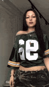 a woman wearing a green jersey with the number 32 on the front