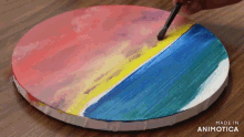 a person is painting a picture of a beach on a round canvas made in animatica