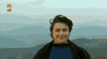 a woman is smiling in front of a tv screen that says atv