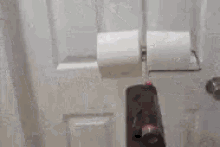 a person is standing in front of a white door with a pink object in their hand .