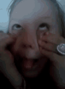 a little girl with a ring on her finger making a face
