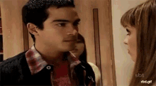 a man and a woman are looking into each other 's eyes while standing next to each other .