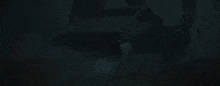 darth vader is standing in a dark room with a red light behind him .