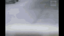 a car is driving down a snowy road and smoke is coming out of the car .