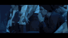 a woman with a ring on her finger praying in a dark room