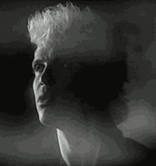 a black and white photo of a man 's face with a shadow on his face .