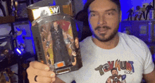 a man wearing a toy hunt t-shirt is holding a toy