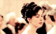 a woman in a white dress is dancing with a crowd of people .