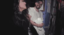 a man with dreadlocks is laughing with a woman