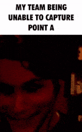 a man is covering his face with his hand in a dark room with the words `` my team being unable to capture point a ''