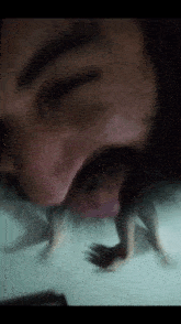 a close up of a man 's face with a beard and a dog 's paws in his mouth .