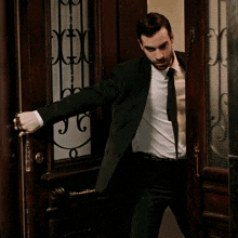 a man in a black jacket is standing in a dark room