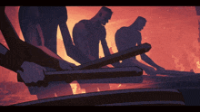 a group of men are holding wooden sticks in front of a burning building