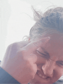 a close up of a person 's face with their finger on their nose