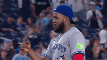 a man wearing a blue jays jersey and a hat
