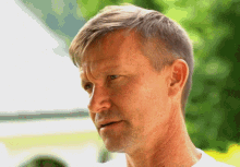 a close up of a man 's face with a green background