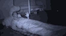 a person wrapped in a sleeping bag with their hand out