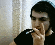 a man wearing headphones with neo on them smoking a cigarette
