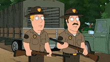 two park rangers are standing next to each other holding guns in front of a truck