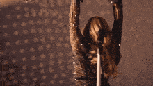 a woman is dancing in front of a microphone in a dark room