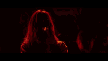 a group of people are standing in a dark room with their hands in the air
