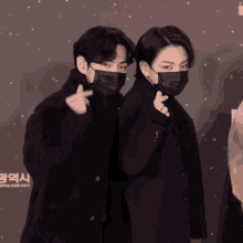 two people wearing face masks are posing for a photo