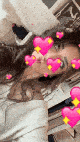 a woman taking a selfie with pink hearts around her face