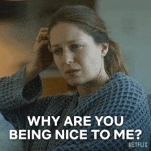 a woman sitting on a couch with a caption that says why are you being nice to me netflix