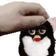 a person is petting a furby penguin toy with a beard .