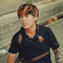 a man wearing a black polo shirt has a tattoo on his arm