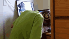 a person wearing headphones looks down at a computer screen