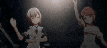 two anime girls are dancing in a dark room .