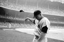 a man in a ny yankees uniform throws a ball