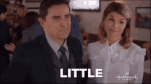 a man in a suit and tie and a woman in a white shirt are standing next to each other .