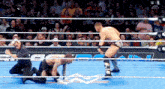 two men are wrestling in a wrestling ring with a crowd watching