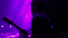 a man is standing on a stage in front of a crowd of people .