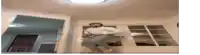 a man is jumping in the air in a living room while wearing a hat .