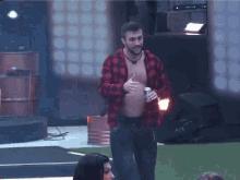 a man without a shirt is holding a can of beer and giving a thumbs up