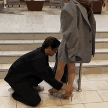 a man is kneeling down to help a woman with her shoes
