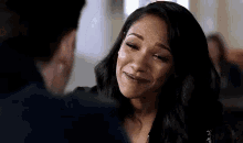 a woman is smiling and looking at a man in a room .