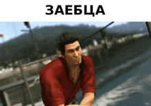 a man in a red shirt is sitting on a boat in front of a body of water and a sign that says zaebcia