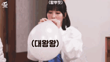 a girl is blowing up a balloon with chinese writing on it .