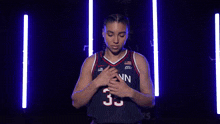 a woman wearing a uconn jersey with the number 35