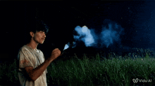 a man blowing blue smoke in a field with a vidu al logo on the bottom